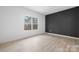 Neutral bedroom features a large window, black accent wall, and modern flooring at 3722 Thompson St, Newton, NC 28658