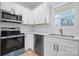 Modern kitchen featuring stainless steel appliances, white cabinets, and wood-look flooring at 3722 Thompson St, Newton, NC 28658