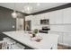 A modern kitchen with stainless steel appliances, white cabinets, a large island and stylish pendant lights at 4228 Legacy Dr, Denver, NC 28037