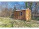 Wooden storage shed in backyard with window and double doors surrounded by chain-link fence at 528 6Th St, Chester, SC 29706