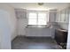 A kitchen with white walls, grey cabinets, a grey sink, and dark flooring at 529 Gage St, Chester, SC 29706