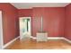 A living room with red walls, wood floors, and multiple doorways at 529 Gage St, Chester, SC 29706
