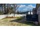 Wide-angle view of a landscaped backyard with a white fence, patio, and inviting egg chair at 5324 Stonewood Dr, Hickory, NC 28602