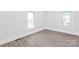 Bright bedroom with light wood-look floors and natural light from two windows at 63 3Rd Nw St, Concord, NC 28027
