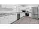 Bright kitchen features stainless appliances, gray counters and backsplash, and white cabinetry at 63 3Rd Nw St, Concord, NC 28027