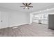 Open concept living room featuring grey flooring and a ceiling fan, with access to the kitchen at 63 3Rd Nw St, Concord, NC 28027