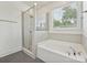 Bathroom featuring a shower with glass door, soaking tub, window, and gray tile flooring at 817 Digby Rd, Rock Hill, SC 29730