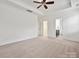 Large bedroom with carpet, tray ceiling, fan, and view of the closet and bathroom at 817 Digby Rd, Rock Hill, SC 29730