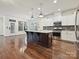 Open kitchen with island, stainless steel appliances, white cabinets and hardwood floors at 817 Digby Rd, Rock Hill, SC 29730