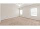 Bright, carpeted bedroom featuring two windows, a ceiling fan and neutral paint at 8500 Union Central Ct, Waxhaw, NC 28173