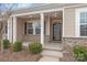 Covered front porch with classic columns, modern lighting, and well-kept shrubbery at 8500 Union Central Ct, Waxhaw, NC 28173