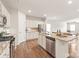 Open kitchen boasts an island, stainless steel appliances, granite counters, and wood flooring at 8500 Union Central Ct, Waxhaw, NC 28173