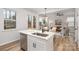 Open kitchen with white cabinets, island, and view into the living room and dining area at 903 Cathey Rd, Charlotte, NC 28214