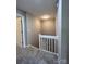 Upstairs hallway with carpeted floors and white railings at 9103 Exbury Ct, Charlotte, NC 28269