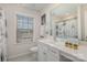 Well-lit bathroom with white cabinets and a window with neighborhood views at 1111 Fairbrae Ln, Indian Trail, NC 28079