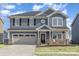 Charming two-story home with a two-car garage and a welcoming front porch at 1111 Fairbrae Ln, Indian Trail, NC 28079