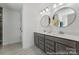 Modern bathroom featuring double vanity, round mirrors, white countertops, and neutral flooring at 112 Stonewater Dr # 33P, Red Cross, NC 28129
