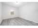 Minimalist bedroom with neutral wall color, window and wood-look flooring at 120 Random Dr, Salisbury, NC 28147