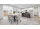 Bright, open kitchen and dining area featuring white cabinets, stainless appliances, and light gray plank floors at 120 Random Dr, Salisbury, NC 28147