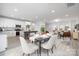 Open-concept kitchen and dining area with modern white cabinetry and stylish furnishings, and light gray plank floors at 120 Random Dr, Salisbury, NC 28147