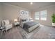 Bedroom featuring a tufted headboard, neutral decor, two windows, and a seating area at 1405 31St Ne St, Conover, NC 28613