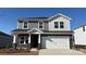 Two-story home featuring stone accents, a white garage door, and a well-manicured lawn on a sunny day at 151 Aberdeen Dr, Salisbury, NC 28144