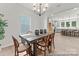 Dining room with a wooden table, seating for six, modern chandelier, and views into the kitchen area at 162 Mooring Dr # 341P, Statesville, NC 28677