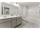 Bright bathroom with dual sinks, a large mirror, decorative plant, and a combo tub and shower at 163 Stonewater Dr # 4P, Red Cross, NC 28129