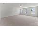 Spacious bedroom with neutral carpet, light gray paint, and three large windows providing ample natural light at 163 Stonewater Dr # 4P, Red Cross, NC 28129