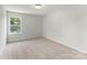 A neutral bedroom with a window allowing for plenty of natural light and neutral carpet at 163 Stonewater Dr # 4P, Red Cross, NC 28129