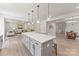 Open-concept kitchen with a large island, pendant lighting, gray cabinets, and views into the living and dining areas at 163 Stonewater Dr # 4P, Red Cross, NC 28129