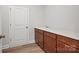 A small laundry area includes base cabinets and a sink, with a white door adjacent to the space at 1726 Riverbend Ave # 177, Belmont, NC 28012