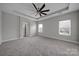 Spacious main bedroom with tray ceiling, a ceiling fan, carpet, and neutral-colored walls at 273 E Waterlynn Rd, Mooresville, NC 28115