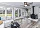 Bright sunroom with a ceiling fan, wood-burning stove, and multiple windows overlooking the backyard at 3642 Litchfield Rd, Charlotte, NC 28211