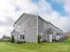 This two story home as a rear exterior of gray siding and a lush green yard at 5006 Kellaher Pl, Charlotte, NC 28216