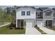 New townhome showcasing two-tone gray and white exterior, attached garages, and landscaped front yard at 5026 Kellaher Pl, Charlotte, NC 28216