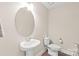 Cozy half-bathroom features a pedestal sink and wood-look flooring at 610 John St, Monroe, NC 28110