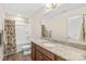 Bright bathroom featuring a granite countertop vanity, shower-tub combo and wood-look flooring at 610 John St, Monroe, NC 28110