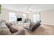 Bright and airy living room featuring a ceiling fan, neutral carpet and sliding glass doors to the outside at 610 John St, Monroe, NC 28110