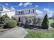 Two-story home featuring a brick facade, dark shutters, mature landscaping, and a covered front porch at 6815 Cabot Cir, Charlotte, NC 28226