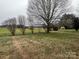 Spacious backyard view featuring a lush green lawn and mature trees creating a tranquil setting at 6901 Green Haven Ln, Monroe, NC 28110