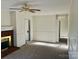 Open living room featuring neutral carpet, brick fireplace, white trim, and ceiling fan at 6901 Green Haven Ln, Monroe, NC 28110