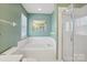 A bright bathroom featuring a soaking tub and a separate glass enclosed shower at 10422 Baskerville Ave, Charlotte, NC 28269