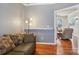 Cozy living room featuring hardwood floors, a comfortable couch, and a view into the next room at 10422 Baskerville Ave, Charlotte, NC 28269