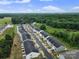 An aerial view of homes in a neighborhood streetscape surrounded by trees, and bright blue skies at 116 Briana Marie Way, Indian Trail, NC 28079