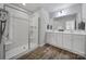 A modern bathroom featuring a glass enclosed shower, double vanity, and wood-look floors at 116 Briana Marie Way, Indian Trail, NC 28079