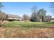 Expansive backyard featuring a well-maintained lawn, mature trees, and a charming storage shed at 121 Easter Ln, Davidson, NC 28036