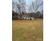 A serene property featuring a well-maintained house, detached garage, and expansive lawn surrounded by tall trees at 1718 Fallston Rd, Shelby, NC 28150