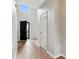 Hallway with hardwood floors leading to the front door and a white door at 1836 Danny Ct, Matthews, NC 28105