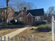 Charming brick home with a red front door and a well-maintained front yard with walkway and white picket fence at 2220 The Plz, Charlotte, NC 28205